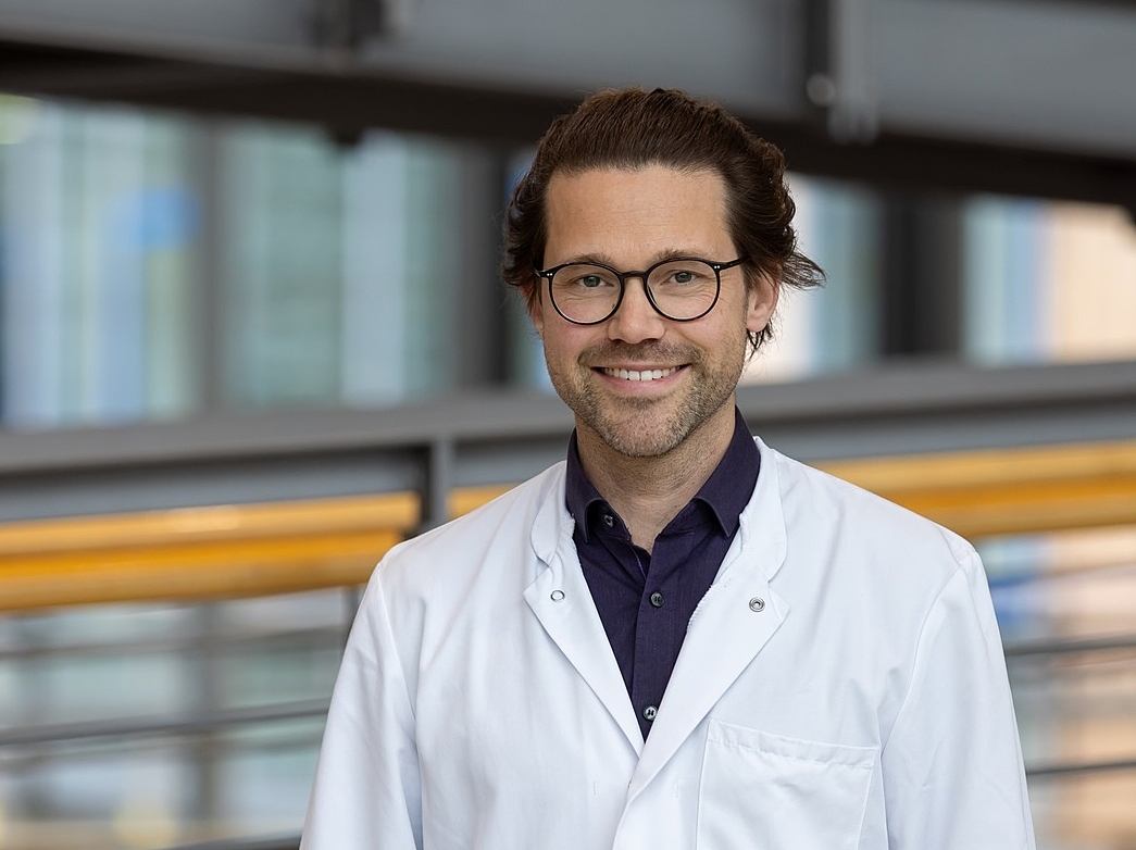 Dr. med. Busch Ein Arzt lächelt in die Kamera.