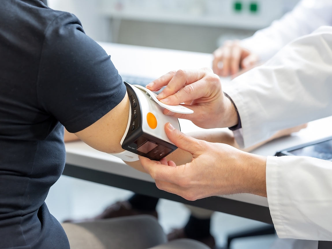 Eine Patientin wird von einem Arzt mit dem Nachblutungsdetektor untersucht.